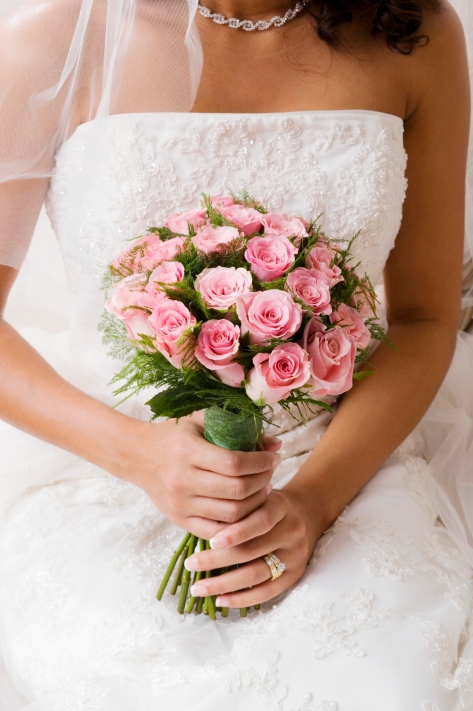 Bride holding bouquet of  pink roses
